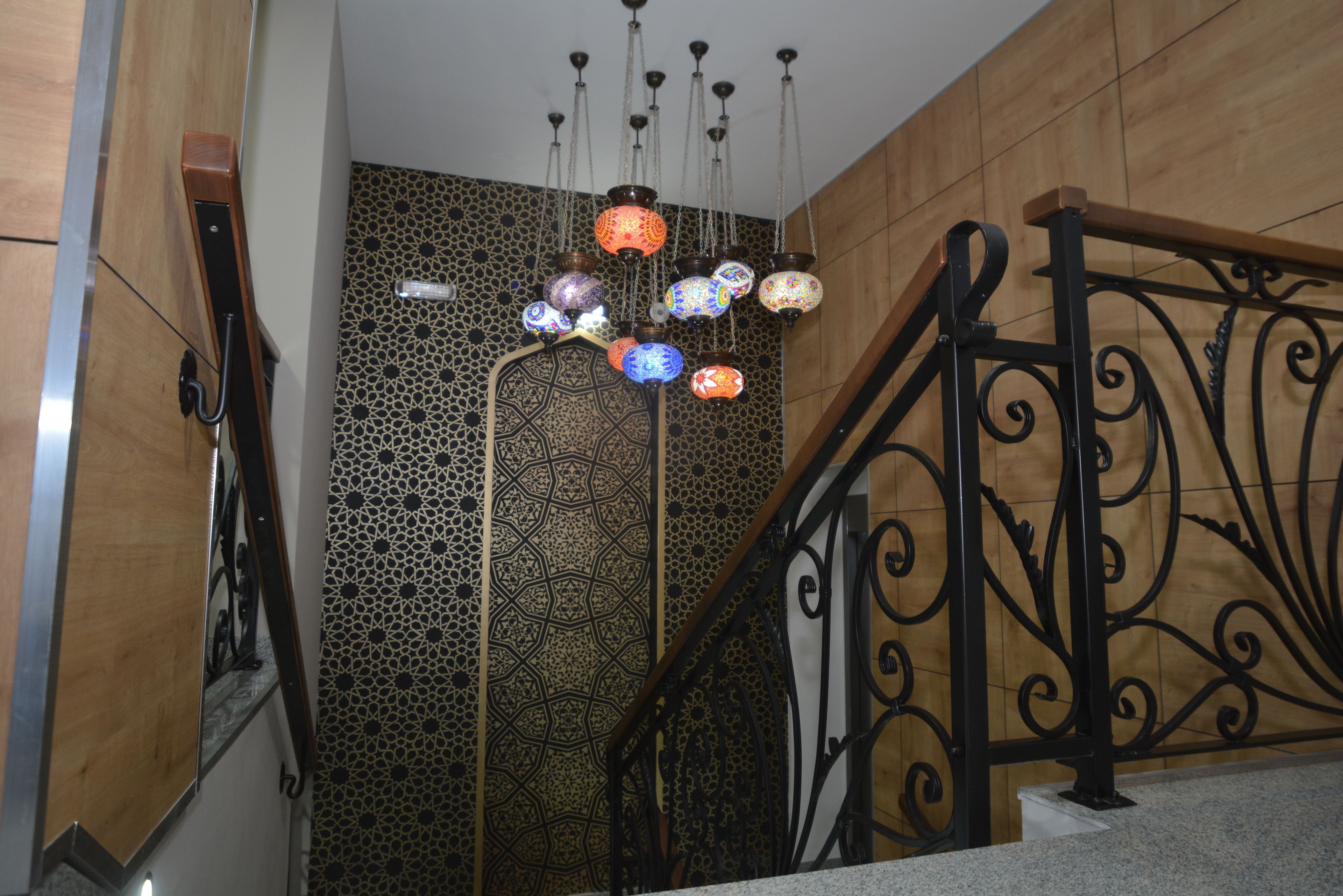 A staircase with ornate metal railings and patterned wall tiles.
