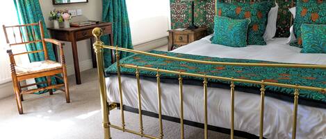 Un dormitorio con cama, silla, escritorio y espejo.