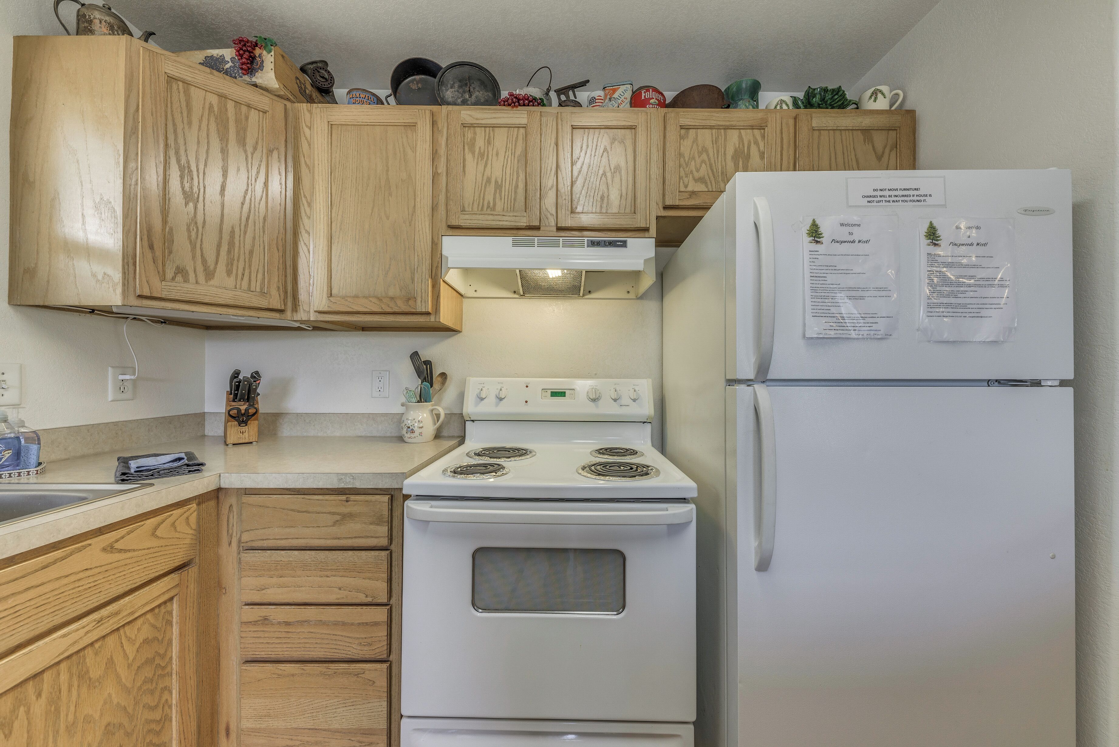 A kitchen with wooden cabinets, a white stove, and a refrigerator.