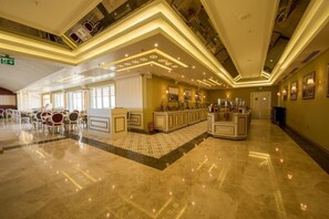 A hotel lobby with a bar area, seating, and a reception desk. - Altin Otel (Ayvalik)