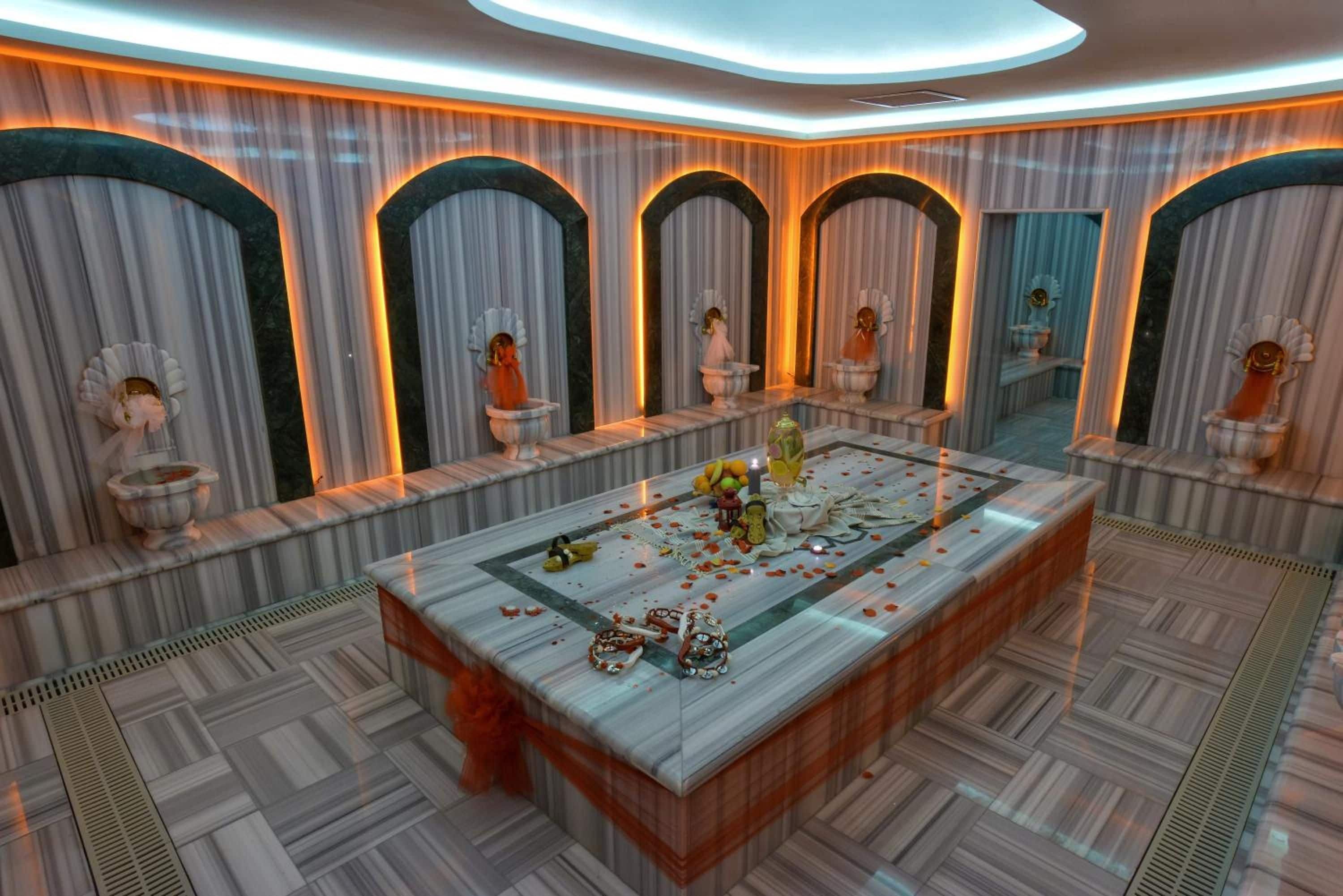 A room with a central table, decorative urns, and a patterned floor.