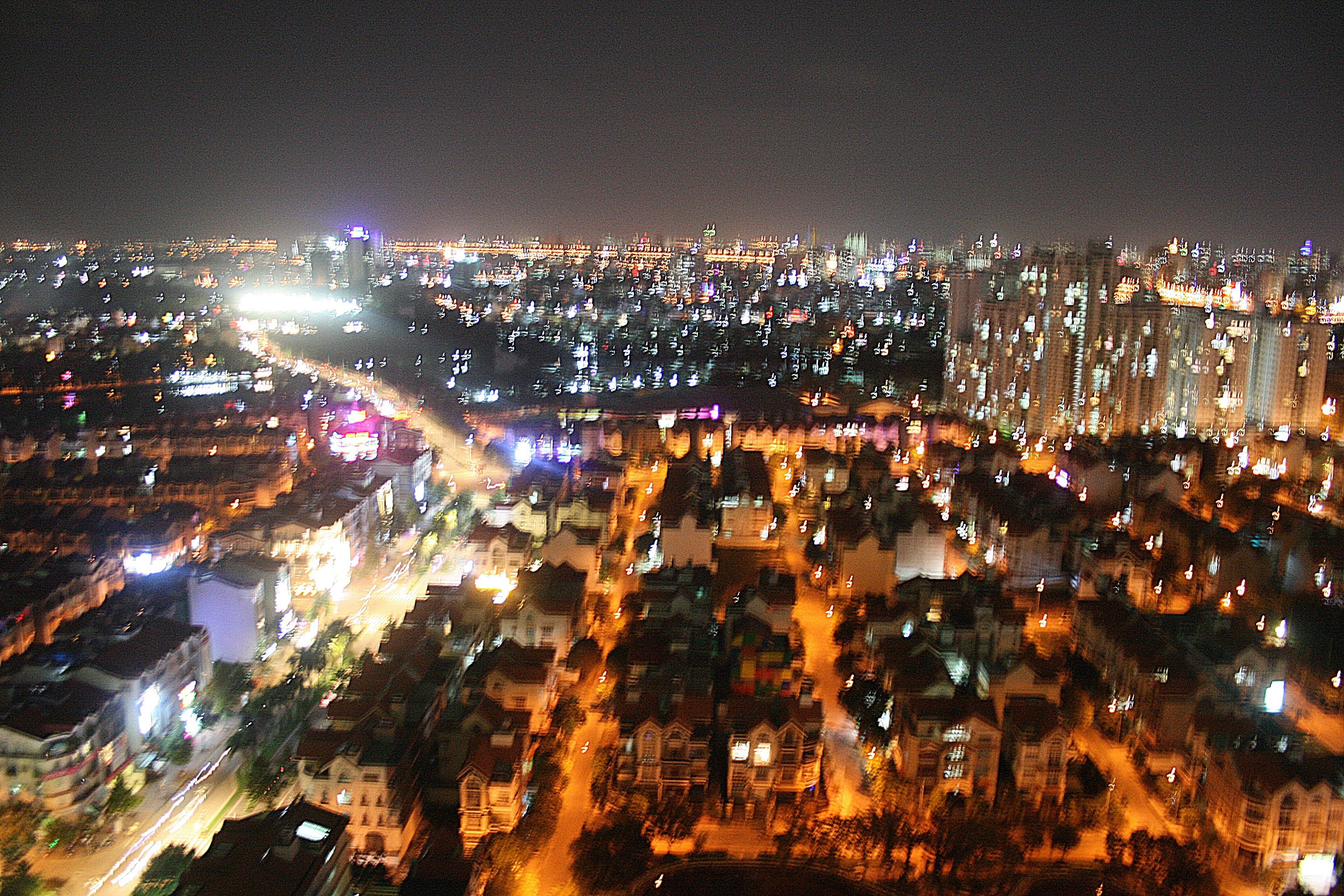 A nighttime cityscape with illuminated buildings and streets.