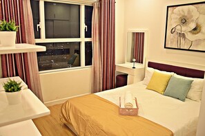 A hotel room with a bed, a bedside table with a plant, a window with curtains, and a painting on the wall. - Sunrise City Luxury New 2bed2bath SW POOL1 (Ho Chi Minh City)