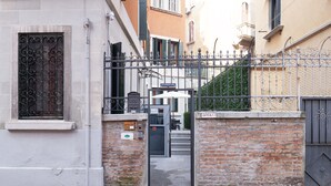 A gated entrance with a metal gate, a mailbox, and a staircase leading to a building. - San Polo Star (Venice)