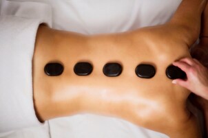 A massage table with five black stones placed in a row.