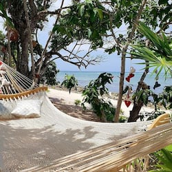 Aan een privéstrand, wit zand, ligstoelen, parasols