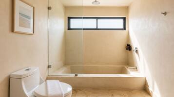 Un baño con inodoro, ducha y ventana.
