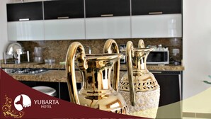 Cozinha com eletrodomésticos modernos e dois vasos dourados decorativos.
