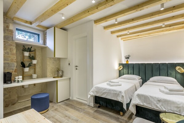 A bedroom with two beds, a desk, and a small seating area. - Luxury Room Miara in Split City Center I (Split)