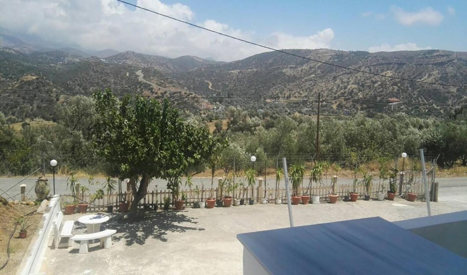 Una terrazza con vista sulle montagne, piante in vaso e mobili da esterno.