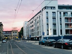Un edificio moderno con un segnale di parcheggio, una linea tramviaria e cielo sereno.