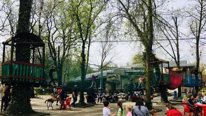 A park with a playground, benches, and trees. - Piper Zajezdnia Blue (Poznan)