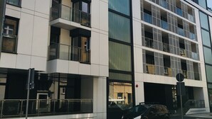 A modern building with multiple balconies, large windows, and a sign indicating it is a hotel. - Piper Zajezdnia Blue (Poznan)