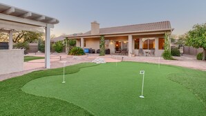 A house with a patio, a lawn, and a small garden. - Club Wolff  West - Enjoy Tucson in Style.  Pool, hot tub, outdoor kitchen, view (Tucson)