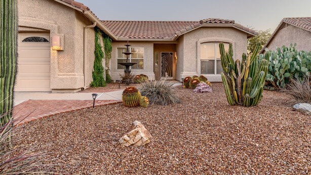 A house with a stucco exterior, a tiled roof, and a gravel driveway. - Club Wolff  West - Enjoy Tucson in Style.  Pool, hot tub, outdoor kitchen, view (Tucson)