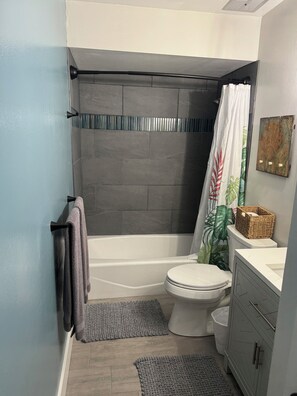 A bathroom with a shower, toilet, and vanity. - Remodeled 2025, king bed, 2 Bathroom, sleeps 4 (Kahuku)