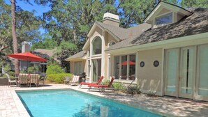 Une maison moderne dotée d’une piscine, de mobilier d’extérieur et d’un espace patio.