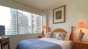 A hotel room with a large bed, two bedside tables with lamps, a TV on a desk, and a window with a city view. - Riverside. Walk to Crown, CBD & MCG. Free Secure Carpark. (MELBOURNE)