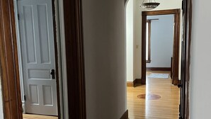 A hallway with wooden floors and white walls.