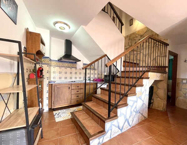 A spacious kitchen with wooden cabinets, a black stove, and a tiled backsplash. - HOLIDAY RENTAL APARTMENT ... 5 KM TO THE NEAREST BEACHES, WIFI, SUNNY TERRACE. GARDEN (Frigiliana)