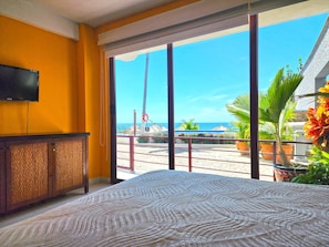 Relax in this serene beachfront room with a large bed, flat-screen TV, and stunning ocean views.