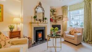 A cozy living room with a fireplace, a sofa, a coffee table, and a television. - New Church Cottage  - sleeps 4 guests  in 2 bedrooms (Tetbury)
