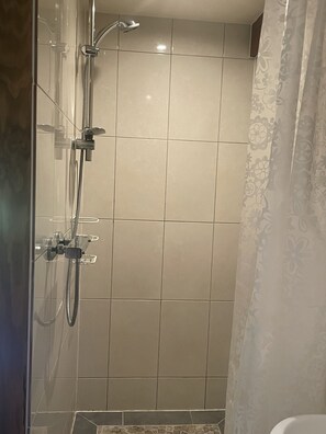 A shower with a glass door, a handheld showerhead, and a wall-mounted faucet. - Cosy Chalet - Sleeps 2-3,  Peaceful Setting, 5kms To Shops,Linen/Towels Included (Romagny Fontenay)