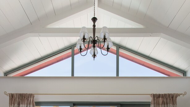 A spacious room with a large sliding glass door leading to an outdoor area with a pool and seating.
