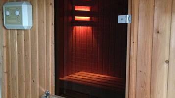 A sauna with wooden walls and a bench inside.