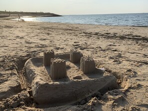 A sandy beach with a sandcastle structure.