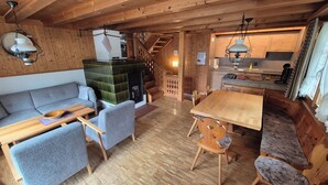 Un intérieur de chalet chaleureux avec un plancher en bois, un canapé, une table à manger et un coin cuisine.