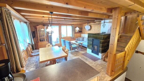 Un intérieur en bois comprenant un coin repas, une cuisine et un escalier.
