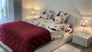 A modern bedroom with a bed, bedside tables, and a hanging light fixture. - Independent house with heated pool (Perigord Noir hamlet) (CARLUX)