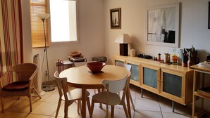 Eine gemütliche Küche mit einem runden Tisch, Stühlen, einem Herd und einem Schrank.
