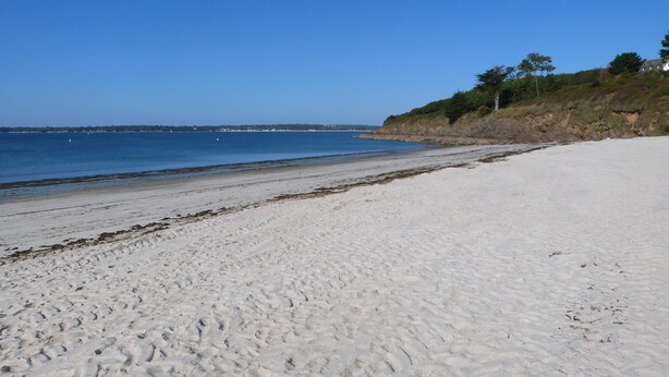 A wide sandy beach with a clear blue sky and calm sea. - Bright tastefully decorated house 300 meters from the Sables Blancs beach. (Concarneau)