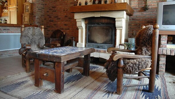 Una sala de estar acogedora con chimenea, muebles de madera y una pared de ladrillo.