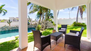 A covered patio area with wicker furniture, a pool, and a view of the surrounding landscape. - Amazing 6,000 sqft house sleeps 10, walk to Beach, Shops and Restaurants (San José del Cabo)