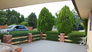 A covered outdoor area with a wooden deck, brick pillars, and a wooden fence. - Golf - Winery - Hike - Bike (Grand Junction)