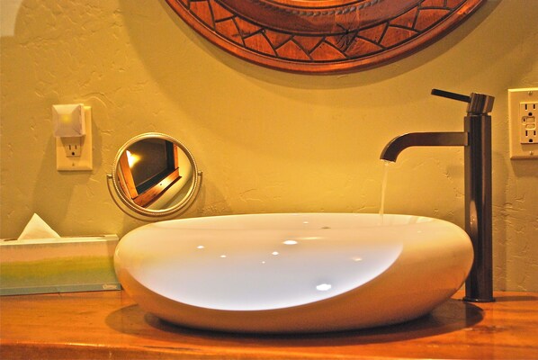 A modern bathroom with a round, white vessel sink, a black faucet, and a mirror on the wall. - 101 Republic Near Yellowstone (Cooke City)