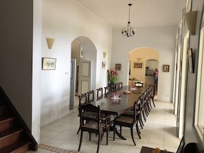A spacious dining area with a long table and multiple chairs, a chandelier, and framed artwork on the walls. - Magnificent colonial villa in a 150 hectares property, Saint Lucia Soufrière (Soufrière)
