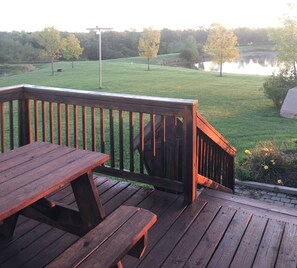 Enjoy a serene outdoor space with a picnic table overlooking a body of water and lush greenery.