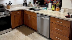 Una cocina moderna con armarios de madera, electrodomésticos de acero inoxidable y un ventanal grande.