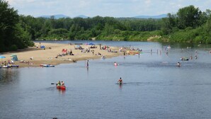 Une plage au bord d’un lac où l’on peut se baigner et faire du kayak.