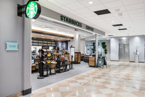 A Starbucks Coffee store with a modern interior, a checkered floor, and a visible elevator. - 4,000+ sq ft beachfront residence + PRIVATE BEACH Resort & Spa by Marriott (Fort Lauderdale)
