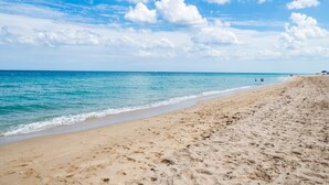 A sandy beach with clear blue water and a few people in the distance. - 4,000+ sq ft beachfront residence + PRIVATE BEACH Resort & Spa by Marriott (Fort Lauderdale)