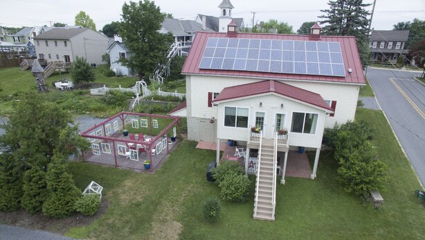A house with a red roof, solar panels, a covered patio, and a small staircase leading to the entrance. - Historic Building, Quiet Location in Beautiful Lancaster County, Stella Side (Terre HIll)