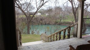 Una escala de pedra que condueix a un porxo amb vista a un llac i cases al fons.