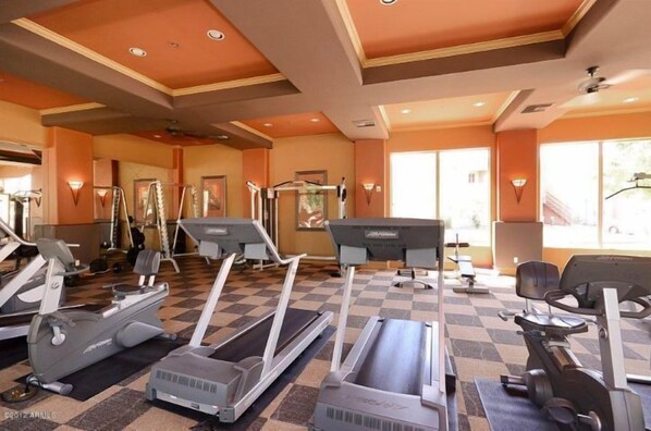 A gym with treadmills, elliptical machines, and weight equipment.