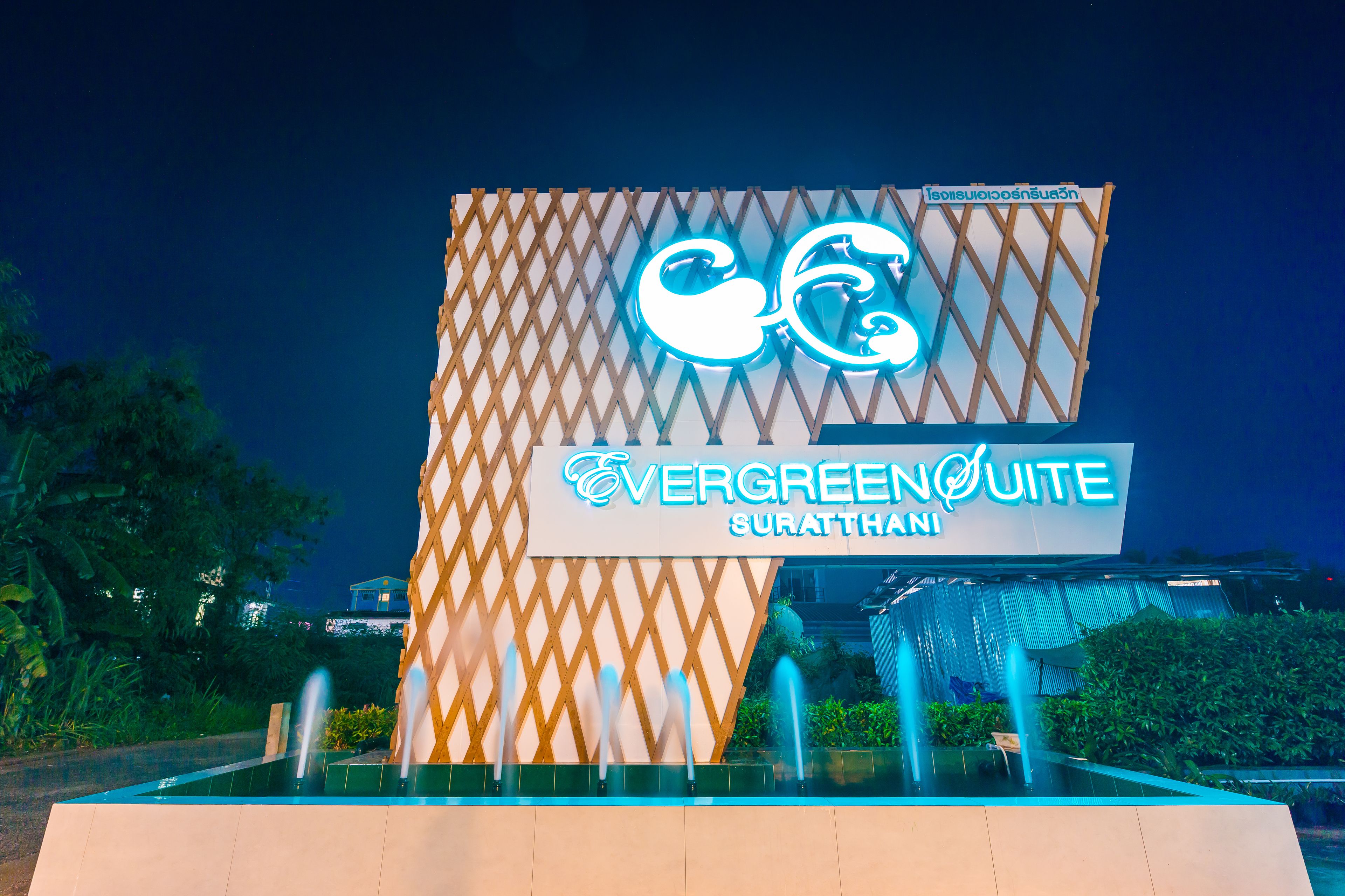 A hotel sign with a geometric design and a neon sign.
