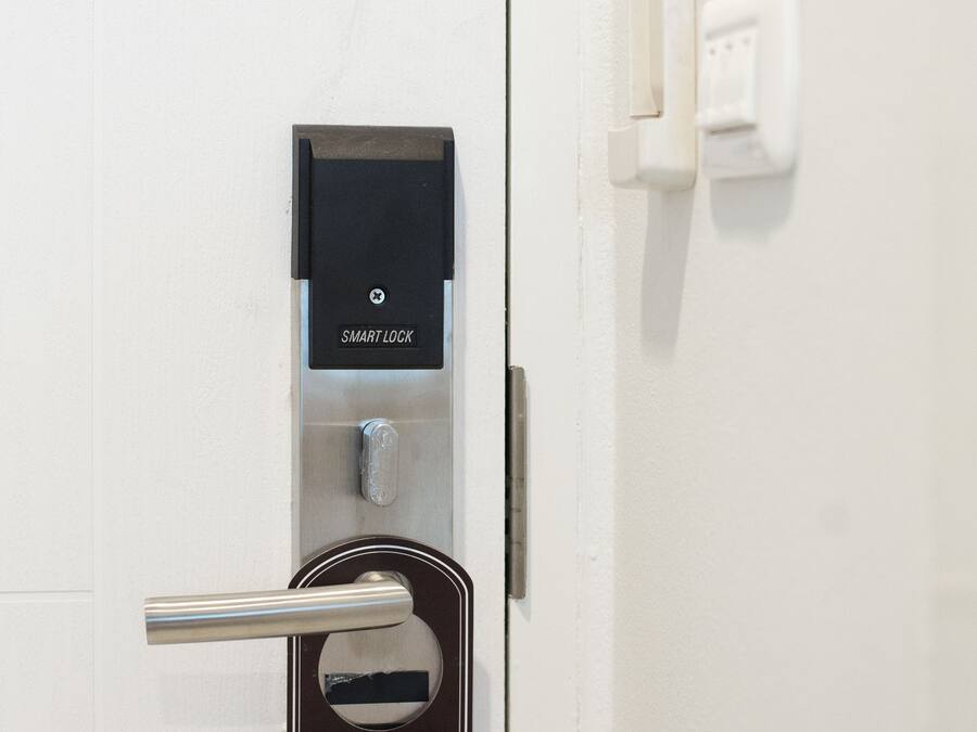 A door with a 'Please Make Up Room' sign, a smart lock, and a card reader.